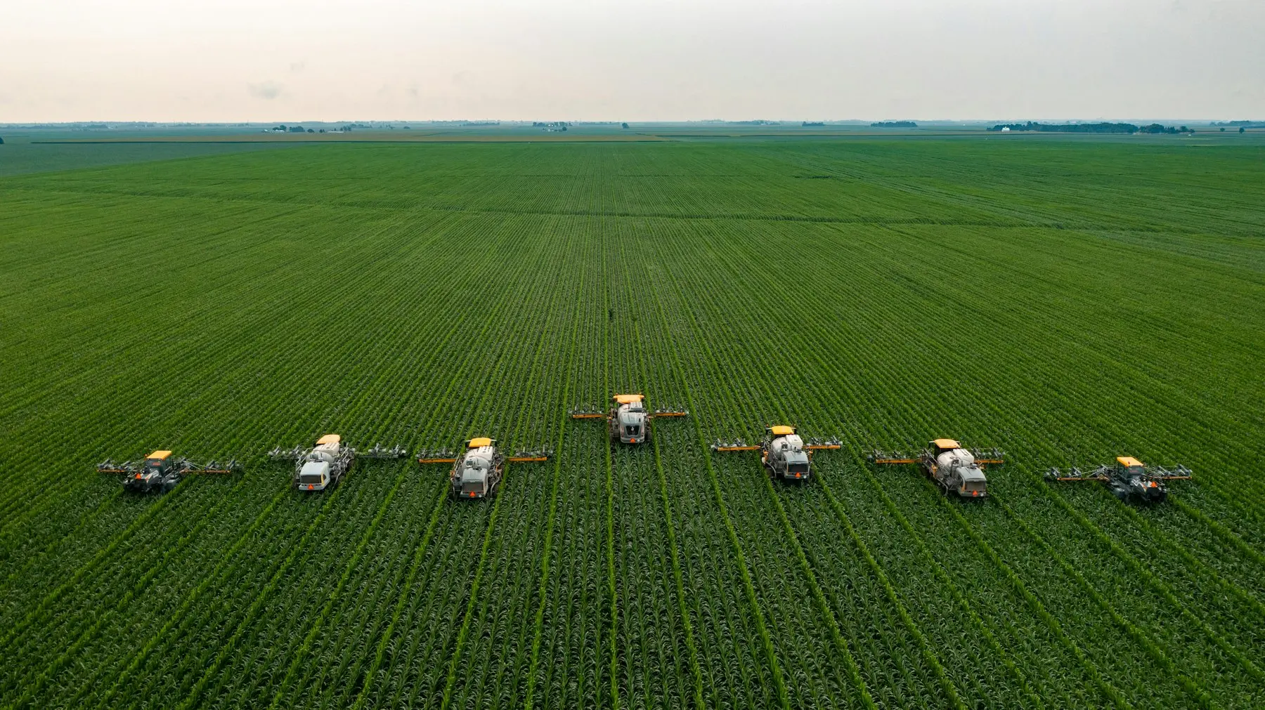 Vista aérea de pulverizadores agrícolas em lavoura